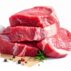 Raw beef steaks stacked with garlic, herbs and pepper on white background, fresh meat for cooking and barbecue